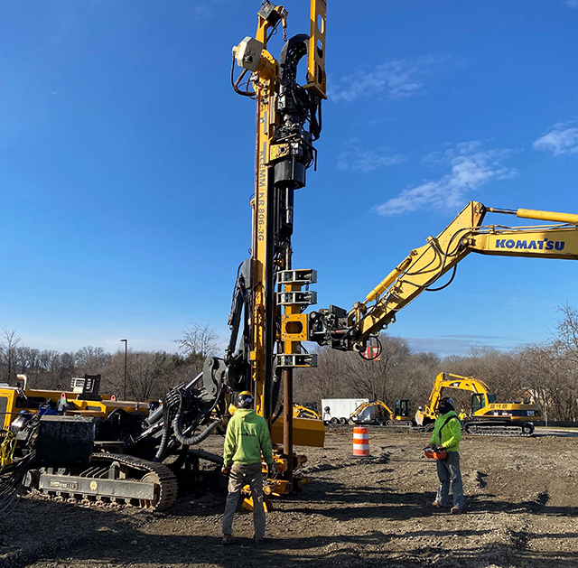 Careful hand signaling was required between a spotter and the equipment operators