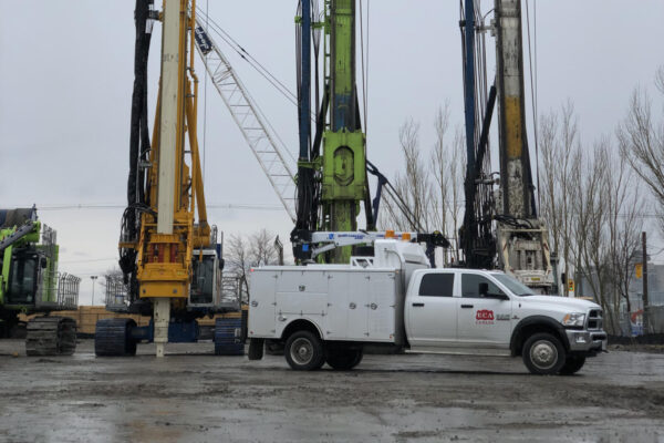 • ECA Canada service technician performing preventive maintenance on foundation drilling equipment.